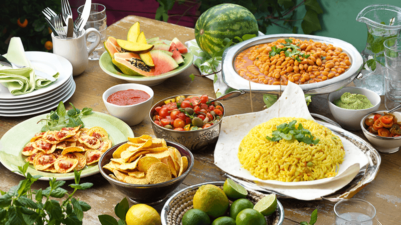 mexican rice, refried beans, nachips and salads etc. served on wooden table