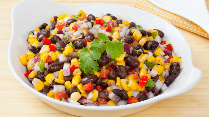mexican side dish corn and black bean salad served in a white bowl