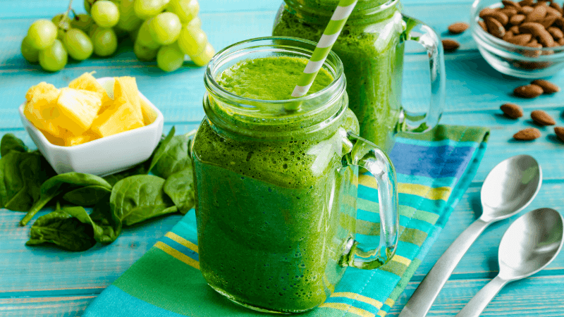 refreshing green vegetable smoothie served in a glass jar with straw