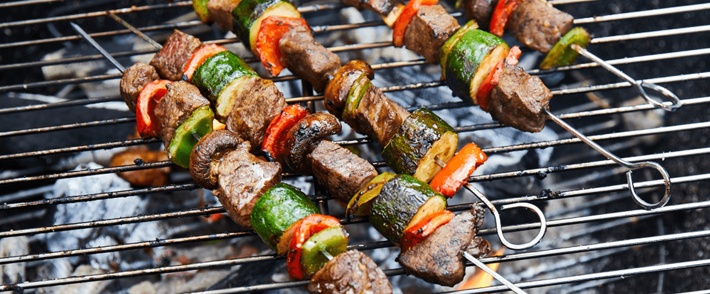 Barbecued sirloin steak, courgette, red and yellow peppers and mushrooms on a skewer