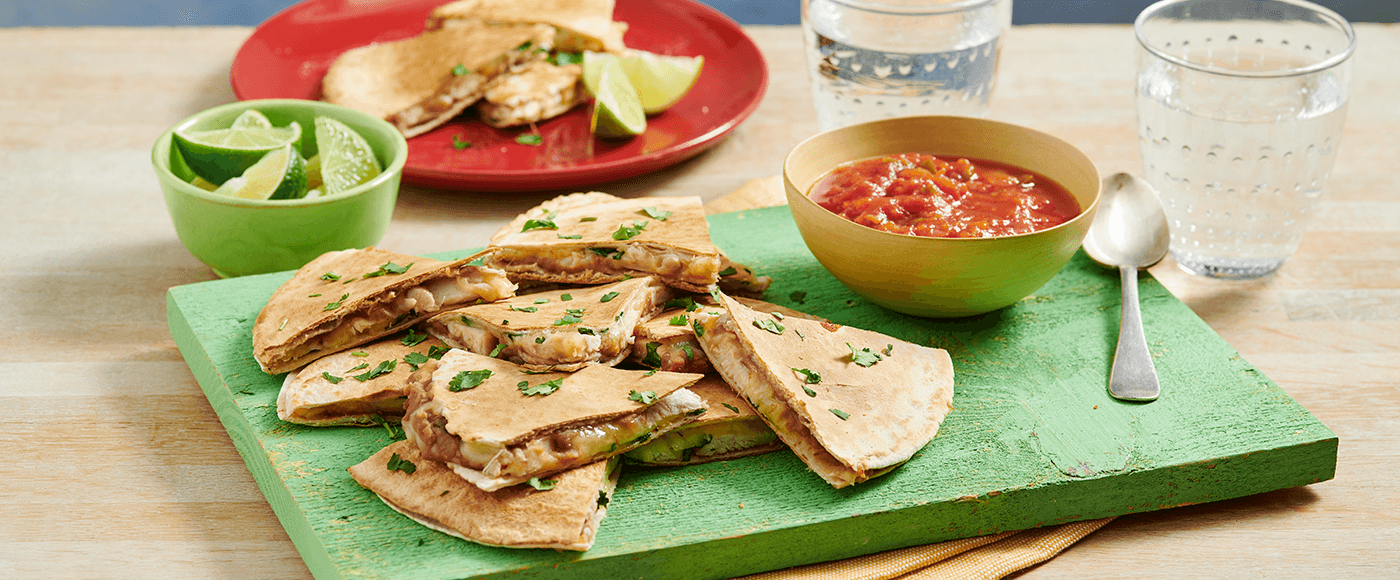 chicken and refried bean quesadillas served on wooden plate with salsa