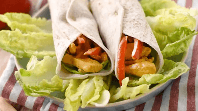 Old El Paso fajitas filled with chicken curry and vegetables sitting on a bed of lettuce