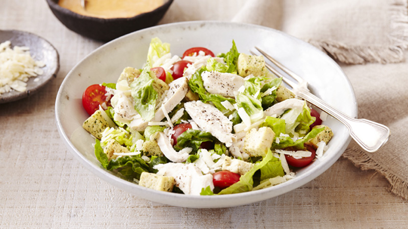 spicy chicken caesar salad served in a white bowl